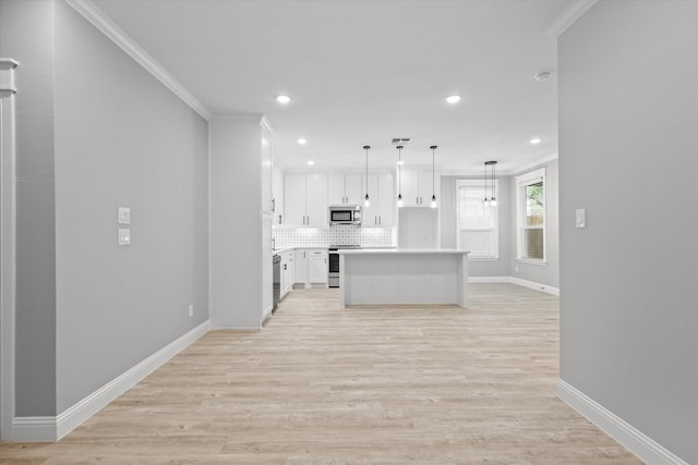 kitchen featuring a center island, white cabinets, ornamental molding, light hardwood / wood-style floors, and stainless steel appliances