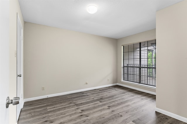 unfurnished room with hardwood / wood-style floors