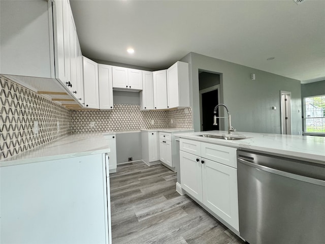 kitchen featuring dishwasher, white cabinets, sink, light hardwood / wood-style flooring, and light stone countertops