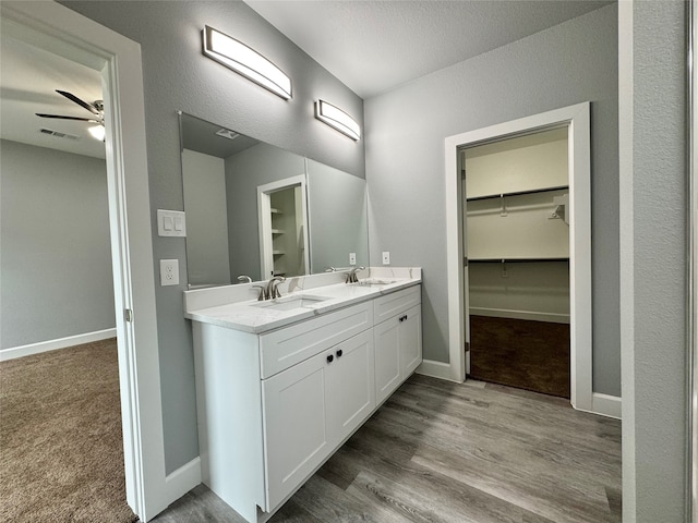 bathroom featuring vanity, ceiling fan, and wood-type flooring