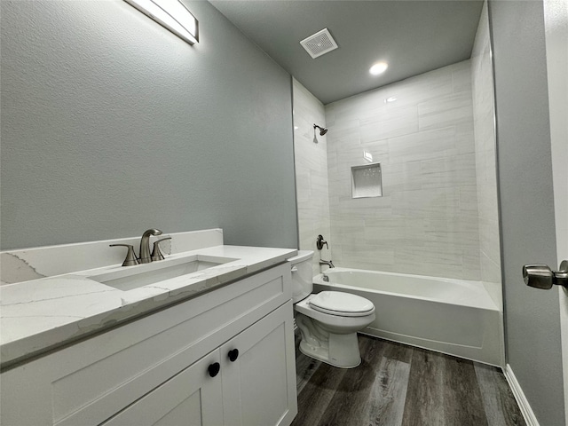 full bathroom featuring hardwood / wood-style flooring, vanity, toilet, and tiled shower / bath combo