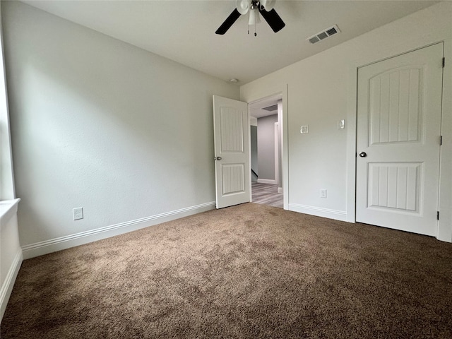 unfurnished bedroom featuring ceiling fan and dark carpet