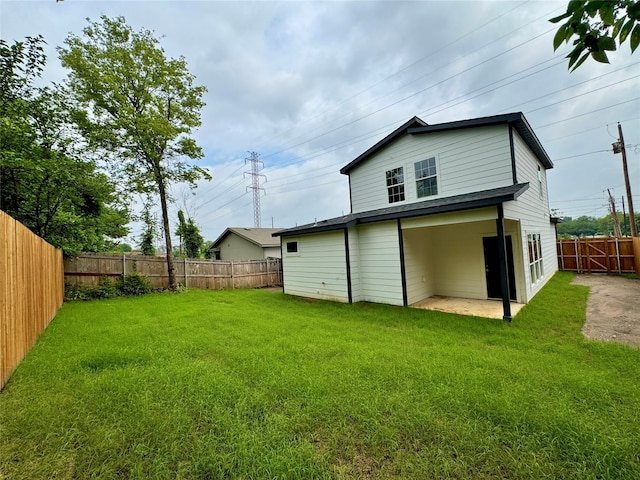 rear view of property featuring a yard and a patio