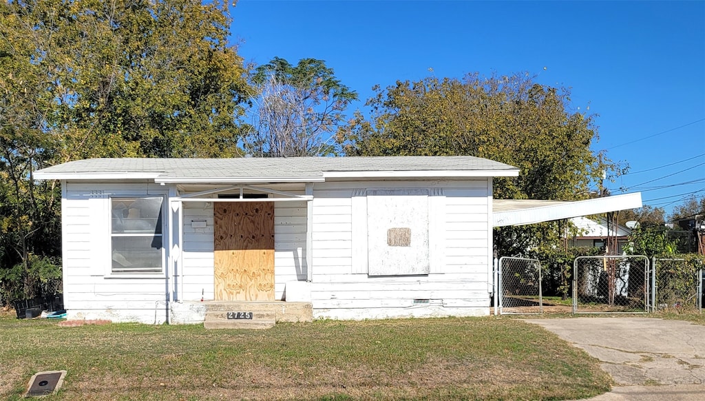 view of front of house with a front lawn and a carport