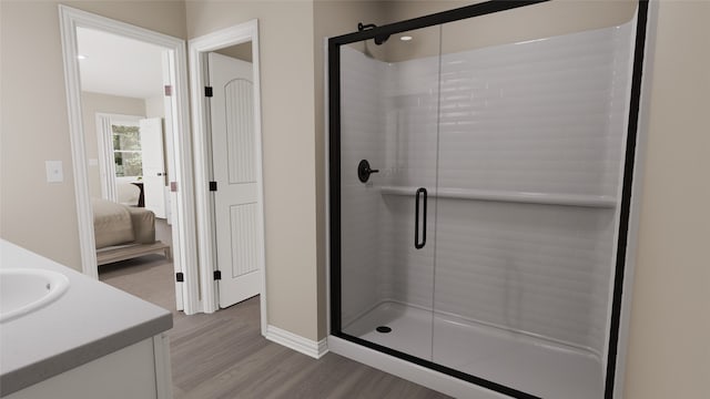 bathroom featuring hardwood / wood-style flooring, vanity, and a shower with door