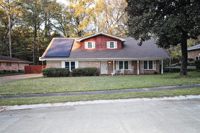 view of front of home featuring a front lawn and solar panels