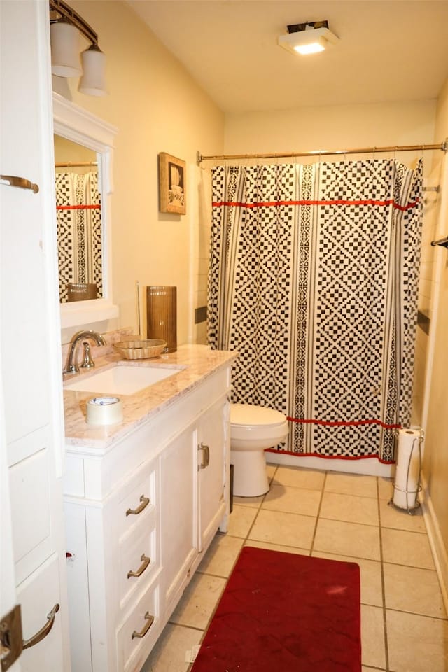 bathroom featuring tile patterned flooring, vanity, curtained shower, and toilet