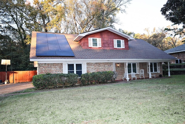 view of front facade with a front yard and solar panels