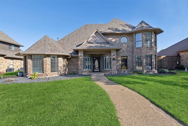 view of front of property featuring central air condition unit and a front lawn