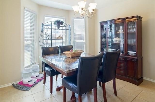 tiled dining room featuring an inviting chandelier