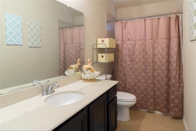 bathroom with vanity, curtained shower, tile patterned floors, and toilet