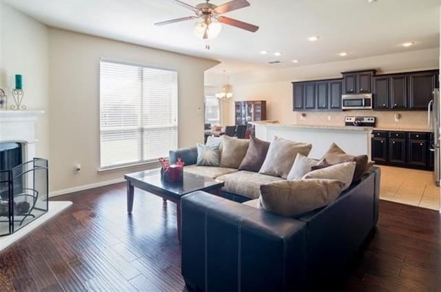 living room featuring ceiling fan and dark hardwood / wood-style flooring