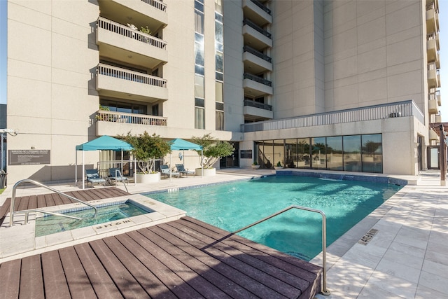 view of swimming pool featuring a patio and a hot tub