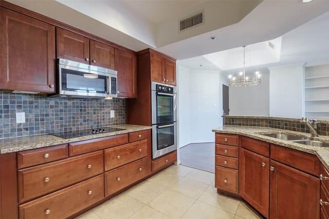 kitchen with sink, backsplash, a chandelier, light tile patterned floors, and appliances with stainless steel finishes