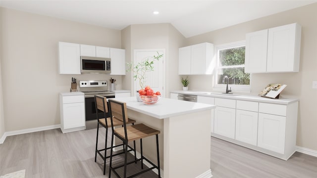 kitchen featuring white cabinets, a center island, stainless steel appliances, and sink