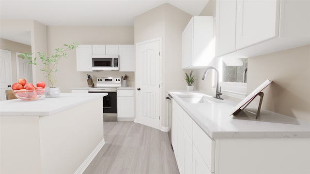 kitchen featuring white cabinetry, sink, light hardwood / wood-style floors, and appliances with stainless steel finishes