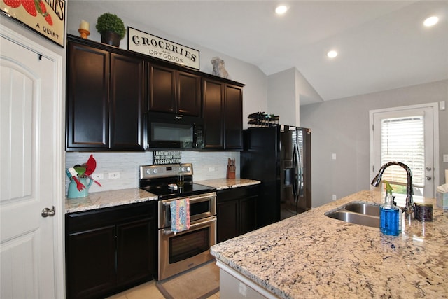 kitchen with black appliances, decorative backsplash, light stone countertops, and sink