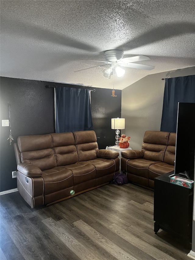 living room featuring ceiling fan, dark hardwood / wood-style floors, and a textured ceiling