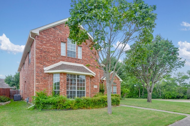 view of front of house featuring central air condition unit and a front lawn