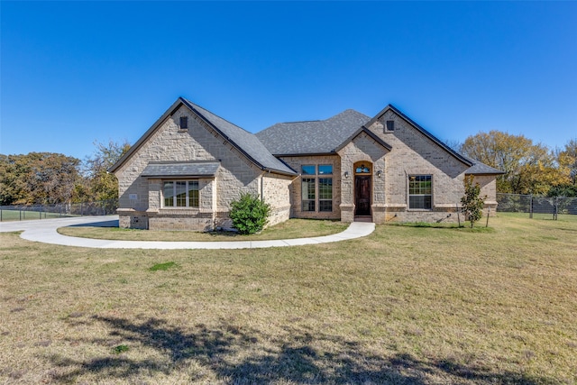 french country style house featuring a front yard