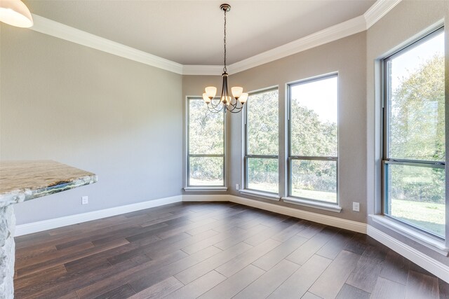 unfurnished dining area featuring dark wood-type flooring, crown molding, and a notable chandelier