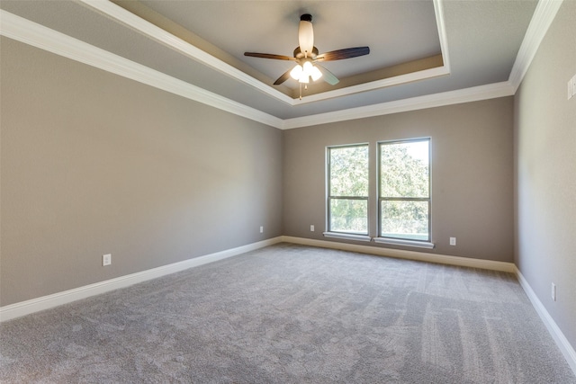 carpeted spare room with crown molding, ceiling fan, and a raised ceiling