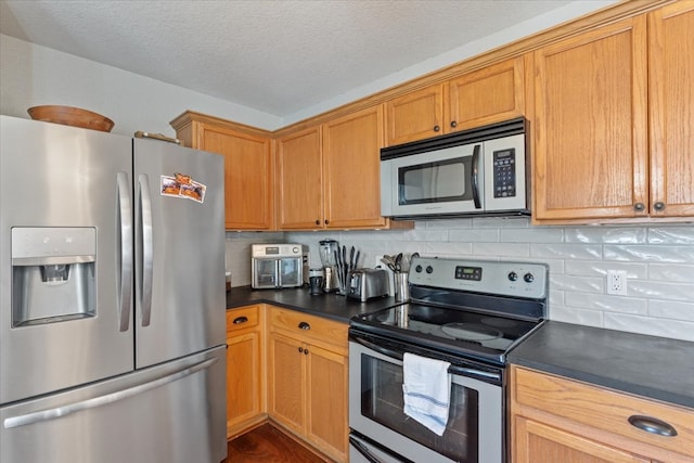 kitchen featuring a textured ceiling, appliances with stainless steel finishes, and tasteful backsplash