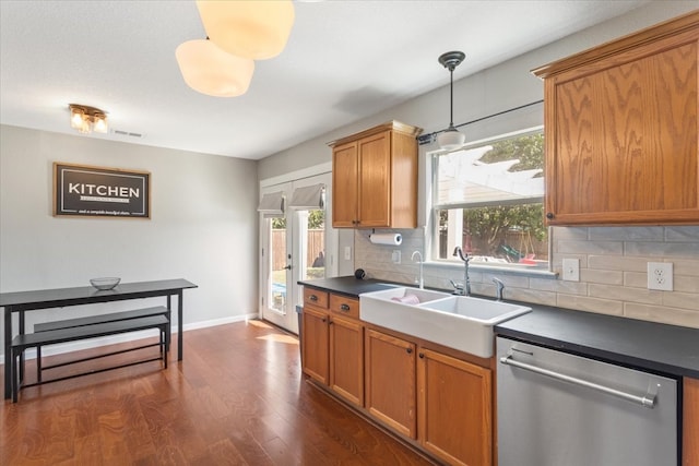 kitchen featuring dishwasher, sink, hanging light fixtures, dark hardwood / wood-style floors, and decorative backsplash