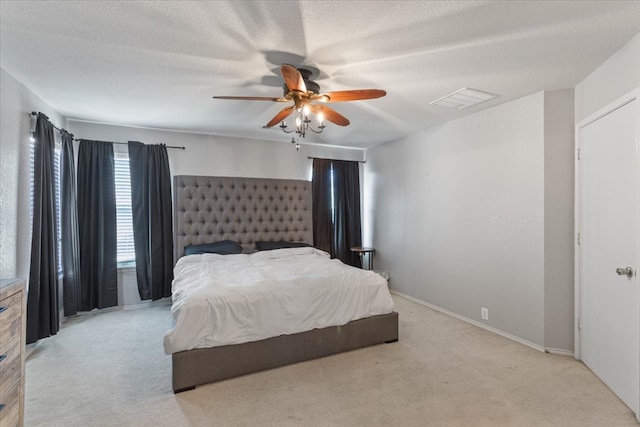 carpeted bedroom featuring ceiling fan and a textured ceiling