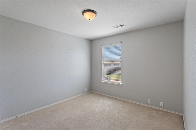 carpeted spare room featuring a textured ceiling