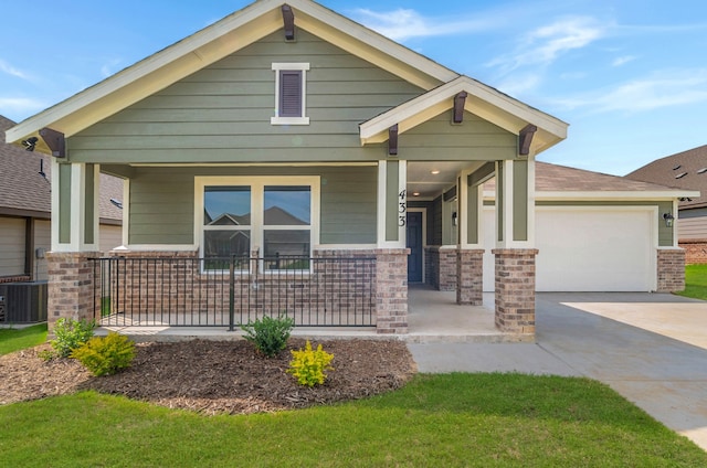 view of front of home featuring central AC, a porch, and a garage