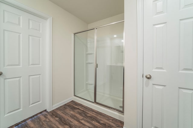 bathroom featuring a shower with door and wood-type flooring