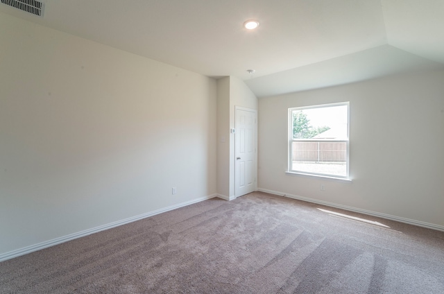 carpeted spare room featuring lofted ceiling