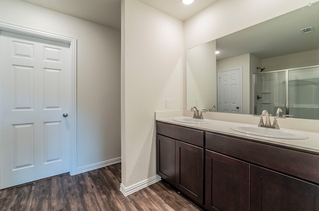 bathroom featuring vanity, hardwood / wood-style flooring, and a shower with shower door