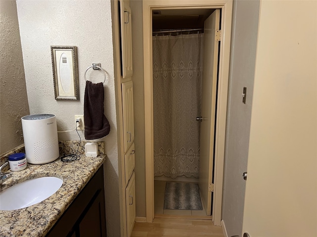 bathroom featuring a shower with curtain, vanity, and hardwood / wood-style flooring