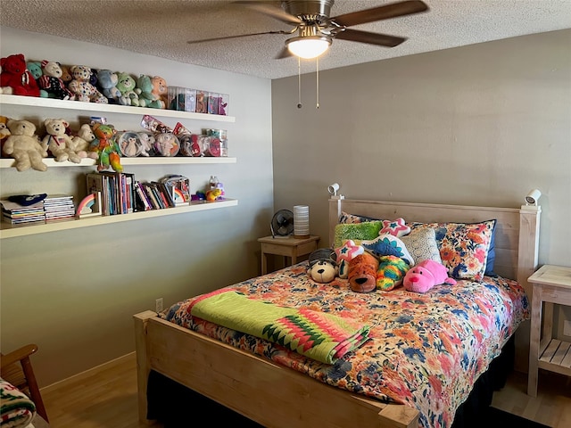 bedroom featuring ceiling fan, wood-type flooring, and a textured ceiling