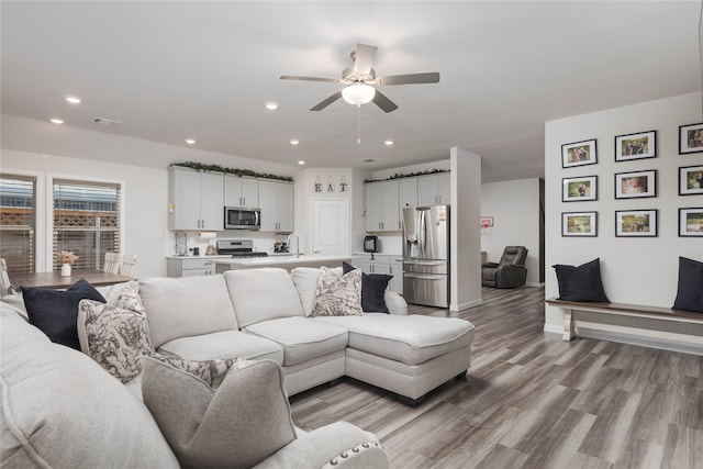 living room featuring light hardwood / wood-style flooring and ceiling fan