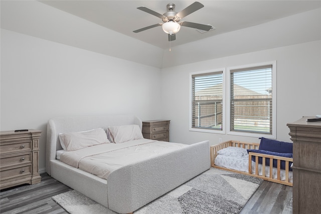 bedroom with dark hardwood / wood-style flooring and ceiling fan