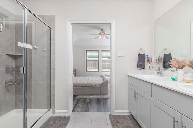 bathroom featuring tile patterned floors, vanity, ceiling fan, and a shower with door