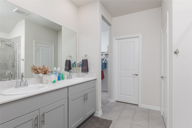 bathroom with tile patterned floors, vanity, and walk in shower