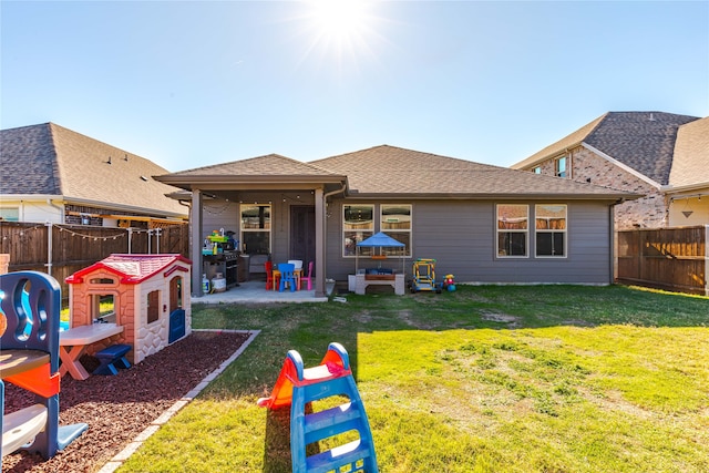 rear view of house with a yard and a patio area