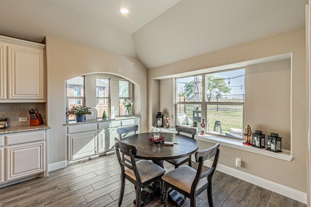 dining area with dark hardwood / wood-style floors and lofted ceiling