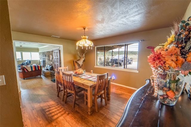 dining space featuring hardwood / wood-style floors and a textured ceiling