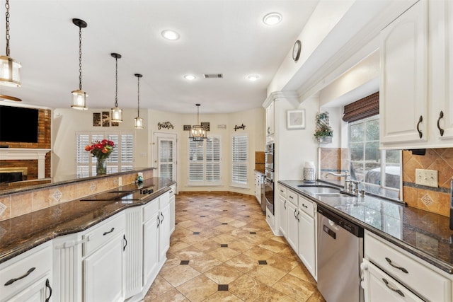 kitchen featuring hanging light fixtures, sink, decorative backsplash, appliances with stainless steel finishes, and white cabinetry