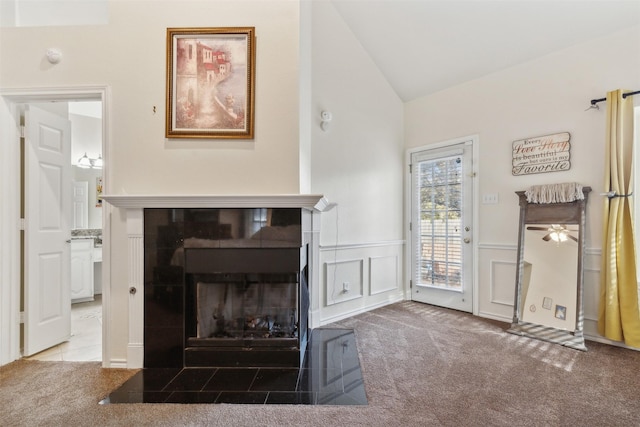 living room with carpet flooring, a tile fireplace, ceiling fan, and lofted ceiling