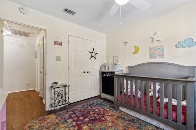 bedroom with ceiling fan, dark wood-type flooring, and a closet