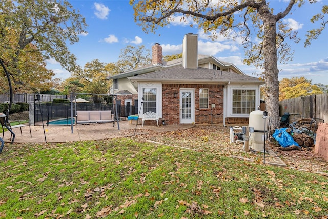 back of house with a fenced in pool and a yard