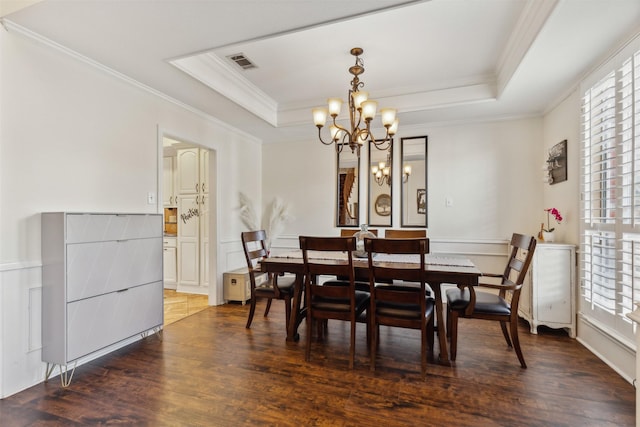 dining space featuring a tray ceiling, crown molding, dark hardwood / wood-style floors, and an inviting chandelier