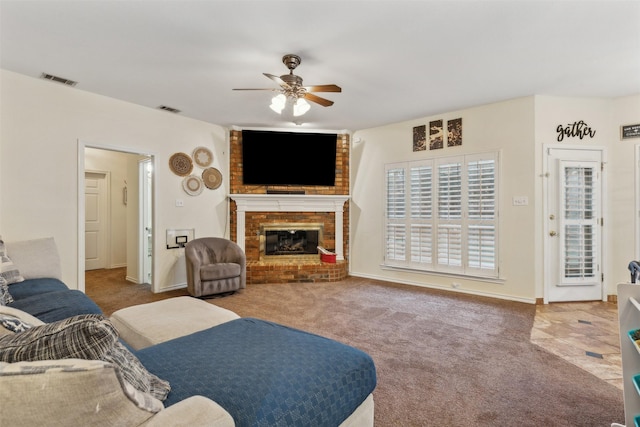 carpeted living room with ceiling fan and a fireplace