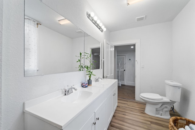 bathroom with hardwood / wood-style floors, vanity, and toilet